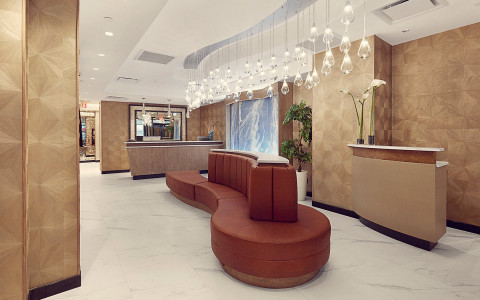 hotel lobby with a seating area and a large lighting fixture hanging from the ceiling 