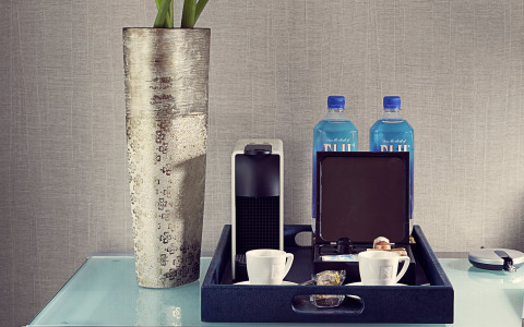 table with a small coffeemaker, coffee cups, chocolates and fiji waters