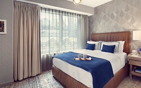hotel room with a queen bed and a large window