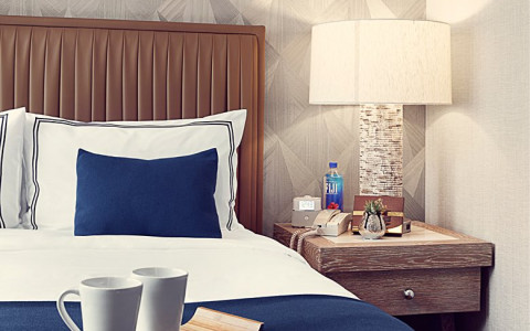 Close up of a queen bed with a nightstand to the right of it. 