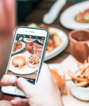 view of a person taking a photo of their plate of food at a restaurant