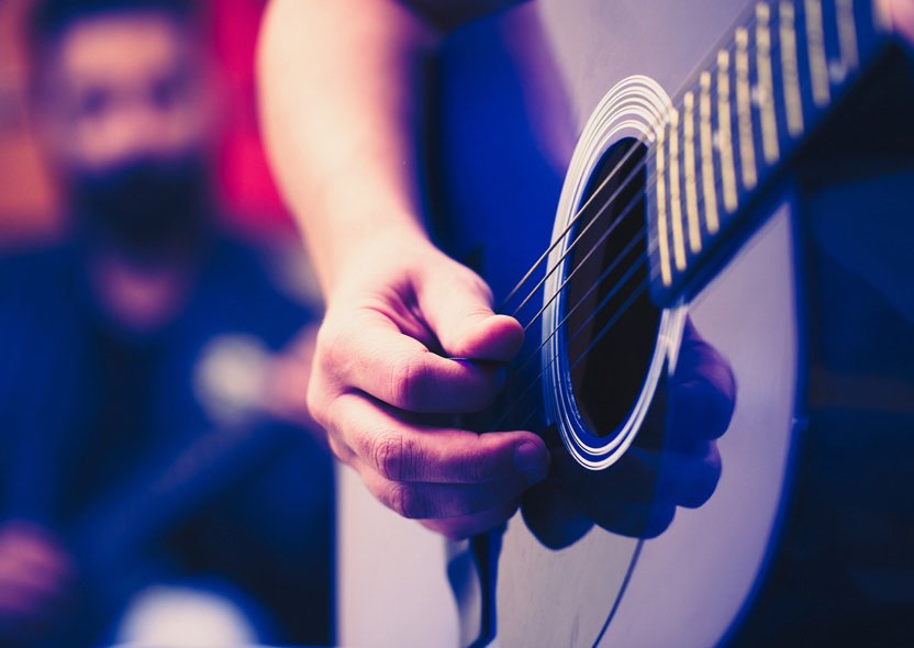 close up of a person playing the guitar