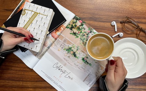 flat lay of magazine with a womans hand holding a coffee cup