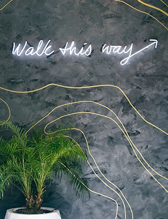 walk this way lit up sign on a wall