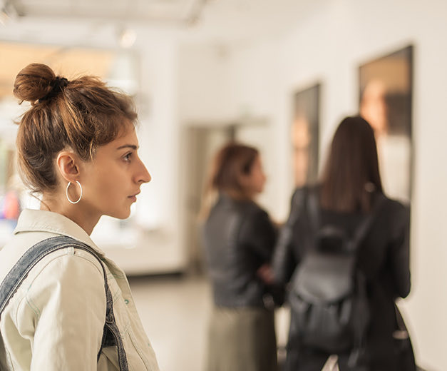 a woman in a museum  looking at art 