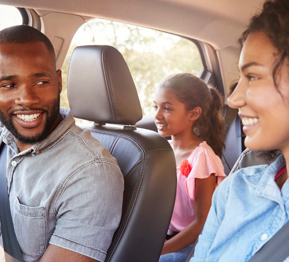family driving in the car smiling during the day