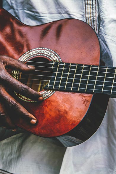 close up of a mans hands playing the guitar