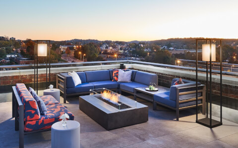 rooftop bar with a fire pit and blue couches