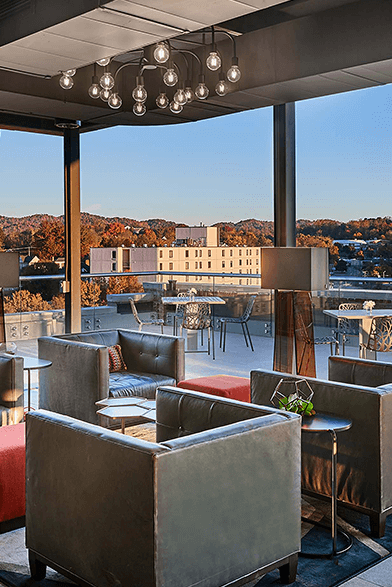 rooftop bar with large sofa chair seating and tables