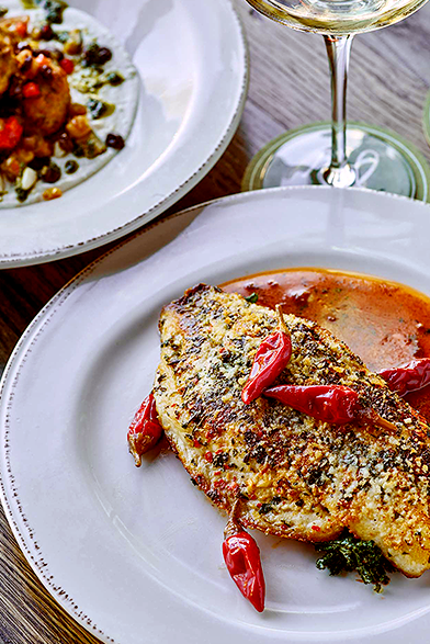 fish filet with red peppers on a white plate