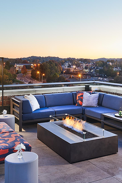 rooftop bar with a fire pit and blue couches