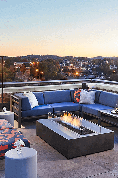 rooftop bar with a fire pit and blue couches