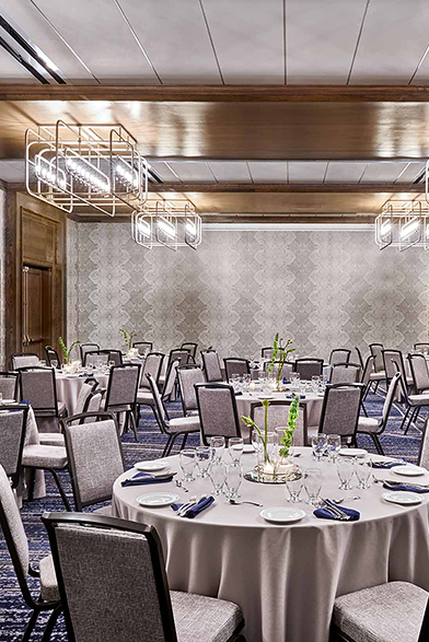meeting space set up for an event with glassware and flowers on the table