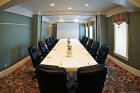 long table in boardroom with black chairs