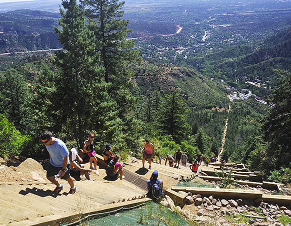 Groups of people hiking up side of mountain trail