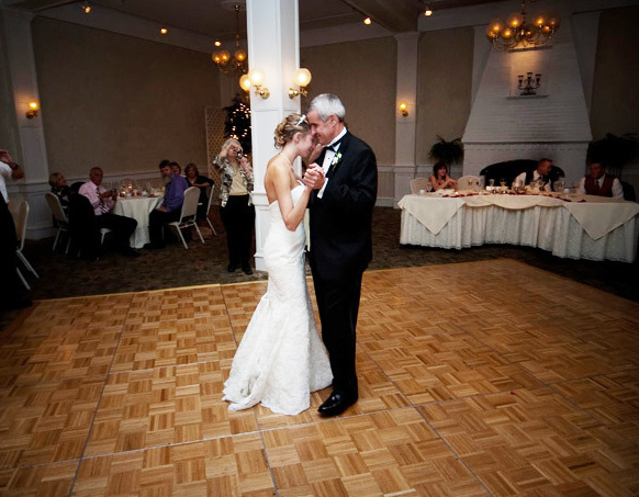 Bride and father dancing in ballroom 