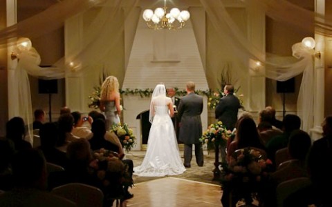 a coupe getting married in front of a crowd