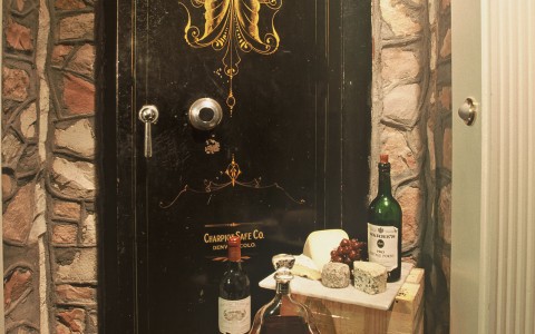 old fashioned safe door, two wooden blocks with wine, grapes and cheese on them