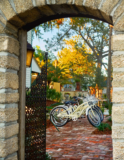 view of bikes through brick and rod iron gate