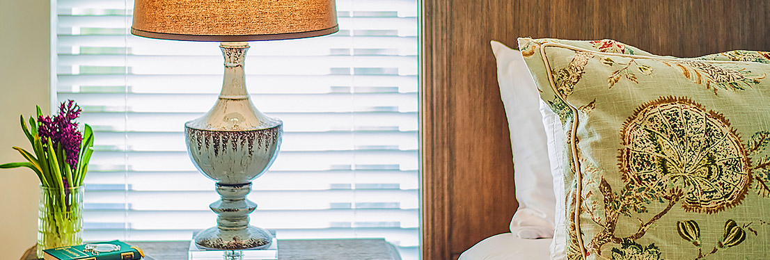 view of bed, side table with lamp, and window