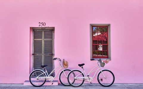 bikes leaning on a pink wall