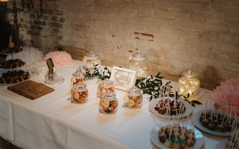 candy table bar with cake pops and mason jars filled with candy 
