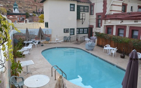 exterior view of the pool with chairs and tables surrounding it