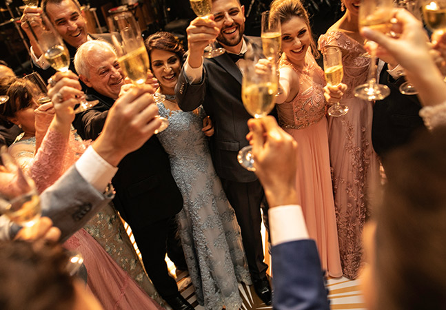 group of people toasting with glasses of champagne while dressed formally