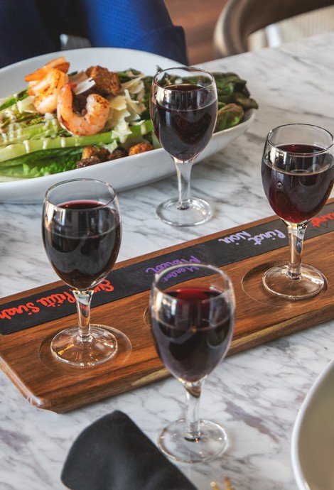 red wine in glasses with two salads