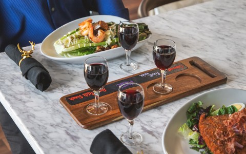 red wine in glasses with two salads