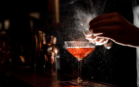 View of a barman preparing a red cocktail 