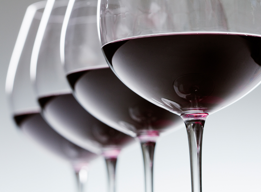 close up view of four glasses of red wine alined
