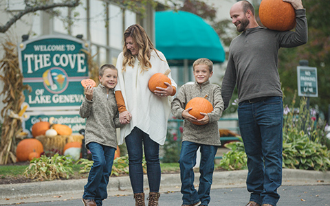 Family of four holding pumpkins
