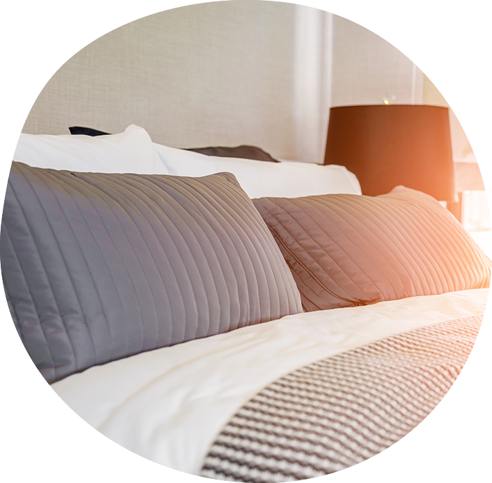 neutral bed linens with a black lamp