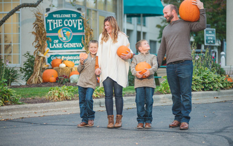 family walking and holding pumpkins together