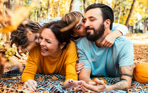 family laying on a blanket in the woods