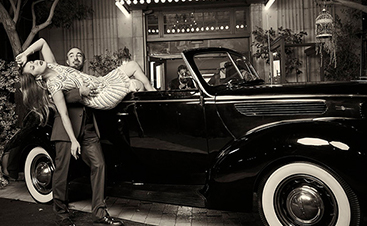 man taking woman out of vintage car