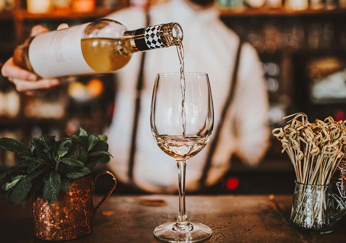 bartender pouring wine into glass