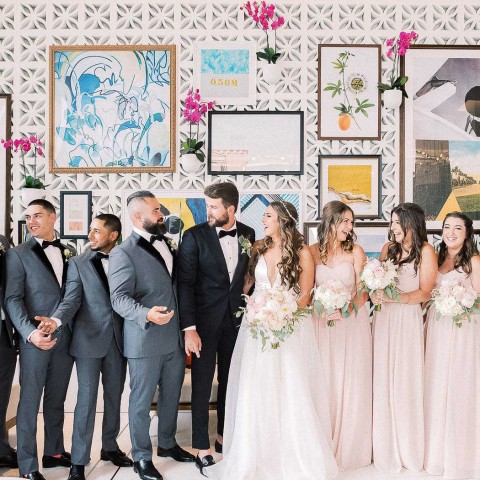 wedding party standing in front of wall of murals