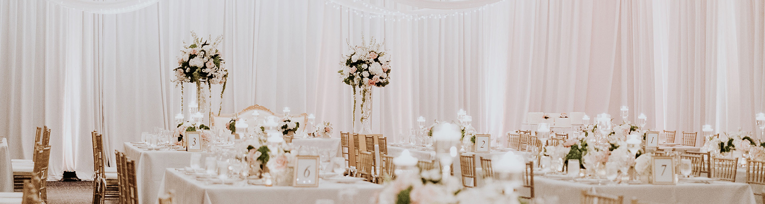 wedding reception with multiple tables and white cloths