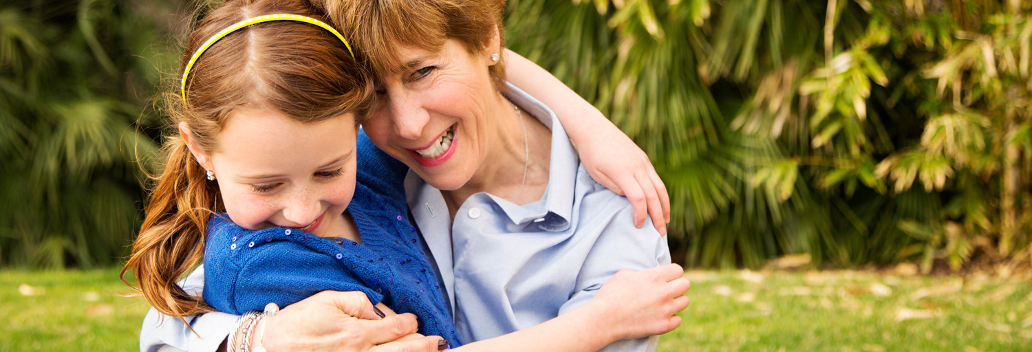 grandma and granddaughter hugging outside