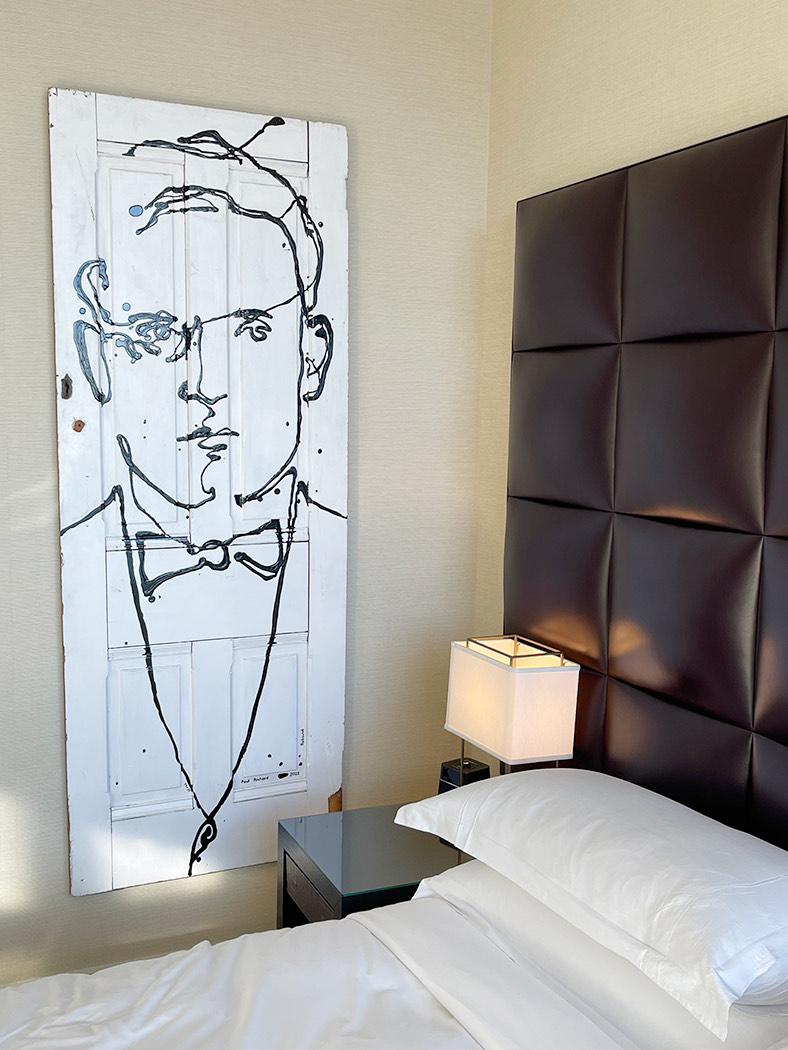 paul richards artwork next to a bed 