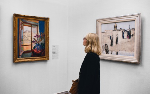 blonde woman admiring art on the wall