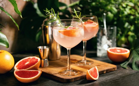 two glasses filled with a grapefruit cocktail