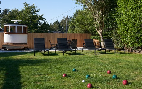 An outdoor grassy area with lounge chairs and a lawn game.