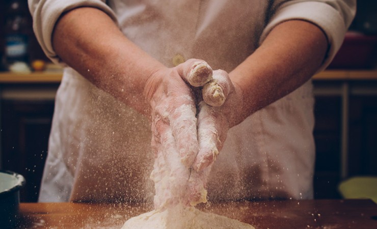 a chef rubbing flour on his hands to cook