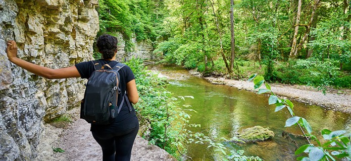 back view of a woman with a backpack looking to the nature