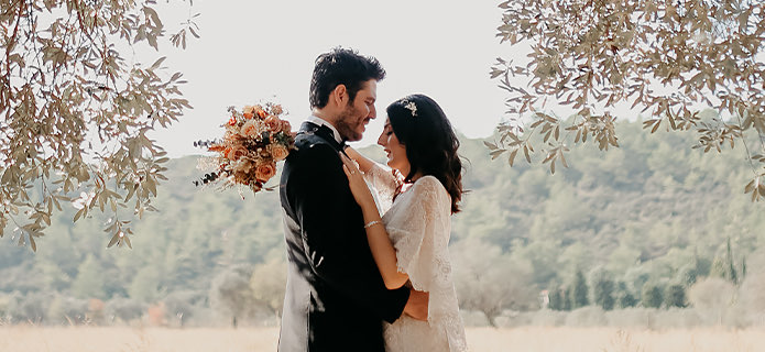 bride with closed eyes embracing groom outdoors