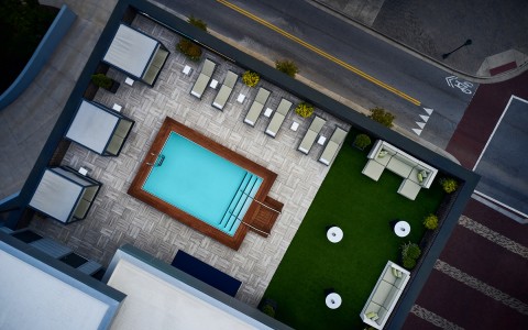 aerial image of the pool area with cabanas, lounge area, and pool chairs 