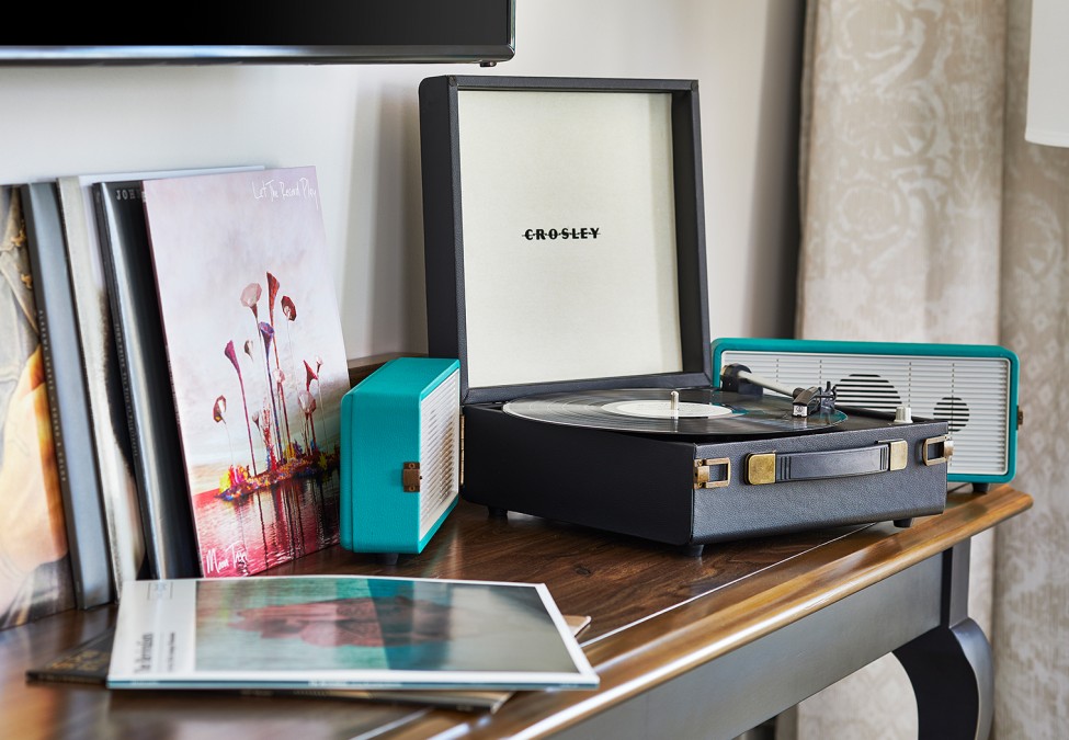 small turntable, small radio and few magazines in a table